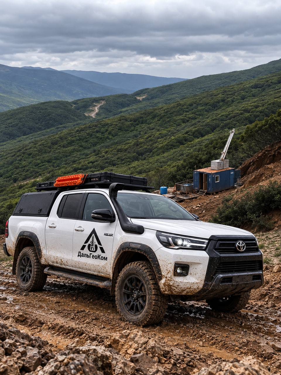 Белый пикап Toyota с логотипом ДальГеоКом на горном участке